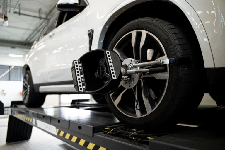 Pomiary geometrii 3D w autoryzowanym serwisie BMW M-Cars - samochód na stanowisku diagnostycznym z głowicą ustawiającą kąty kół, profesjonalna obsługa zimowa.