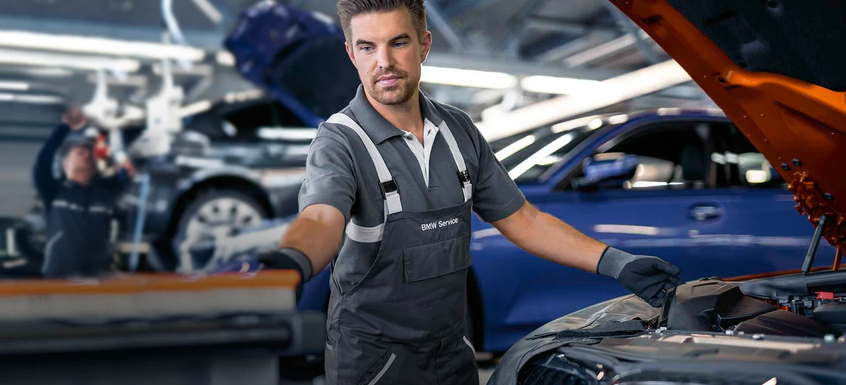 Mechanik BMW w autoryzowanym serwisie sprawdza komorę silnika, przegląd i diagnostyka w BMW M-Cars