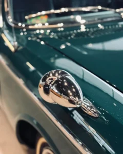 Chromowane lusterko BMW 2000 C na tle lakieru i refleksów światła