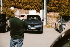 Osoba robiąca zdjęcie BMW iX3 Neue Klasse przed salonem