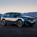 Nowe BMW iX3 2026 w niebieskim kolorze na tle gór