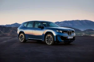 Nowe BMW iX3 2026 w niebieskim kolorze na tle gór
