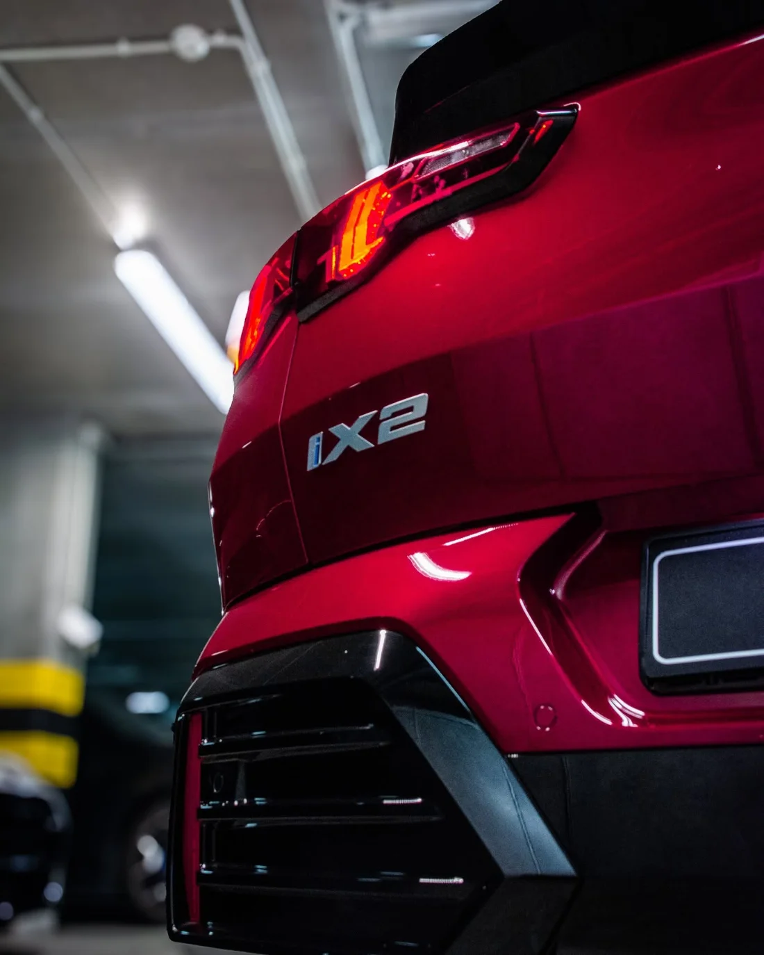 Tylna część czerwonego BMW iX2 eDrive20 2025 z oznaczeniem iX2, elektryczny SUV coupe BMW M-Cars