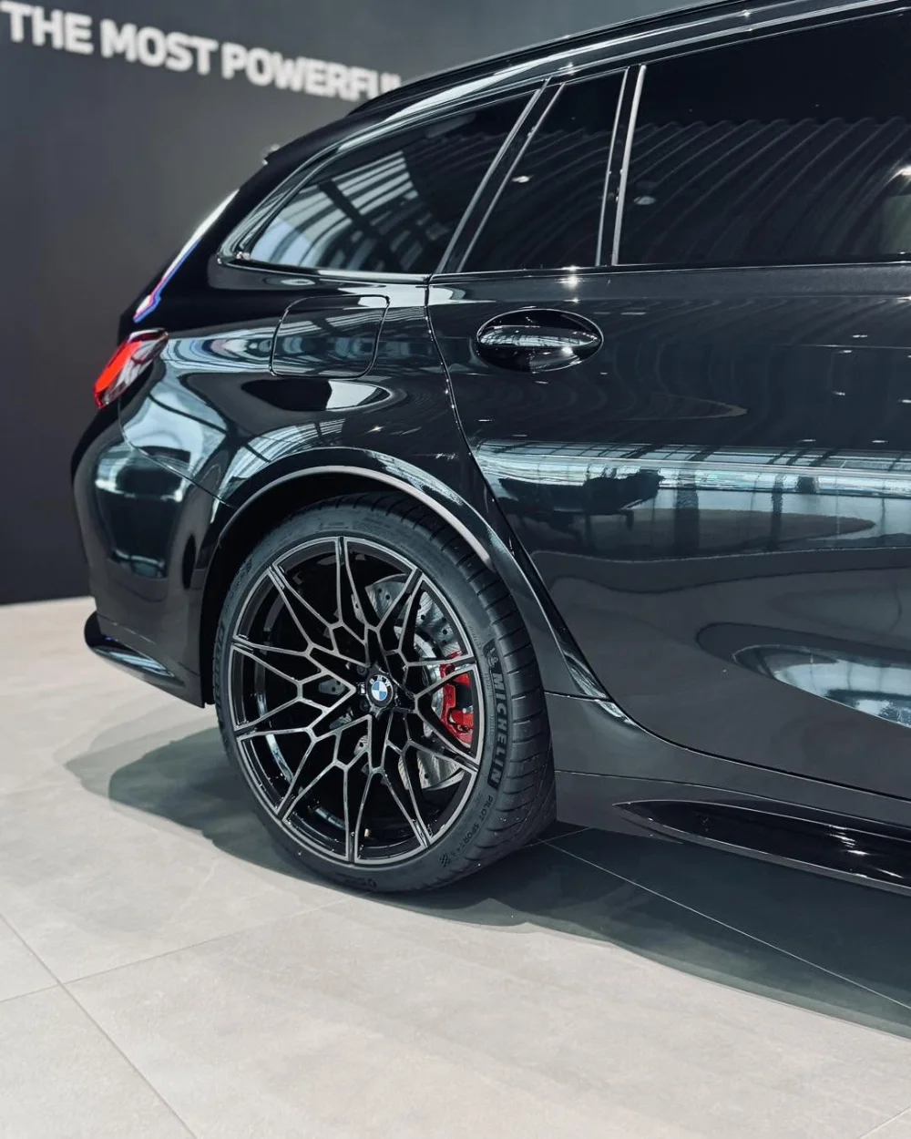 BMW M3 Competition Touring 2026 z boku, felga M i czerwony zacisk hamulcowy w salonie BMW M-Cars