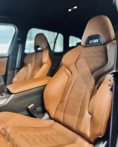 Sportowe fotele BMW M3 Competition Touring 2026 z koniakową tapicerką i logo M3