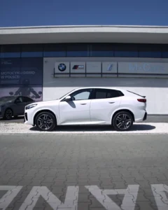 Białe BMW X2 20i z pakietem M z profilu przed salonem BMW M-Cars Kraków