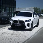 Białe BMW X2 20i z pakietem M, przód samochodu przed salonem M-Cars