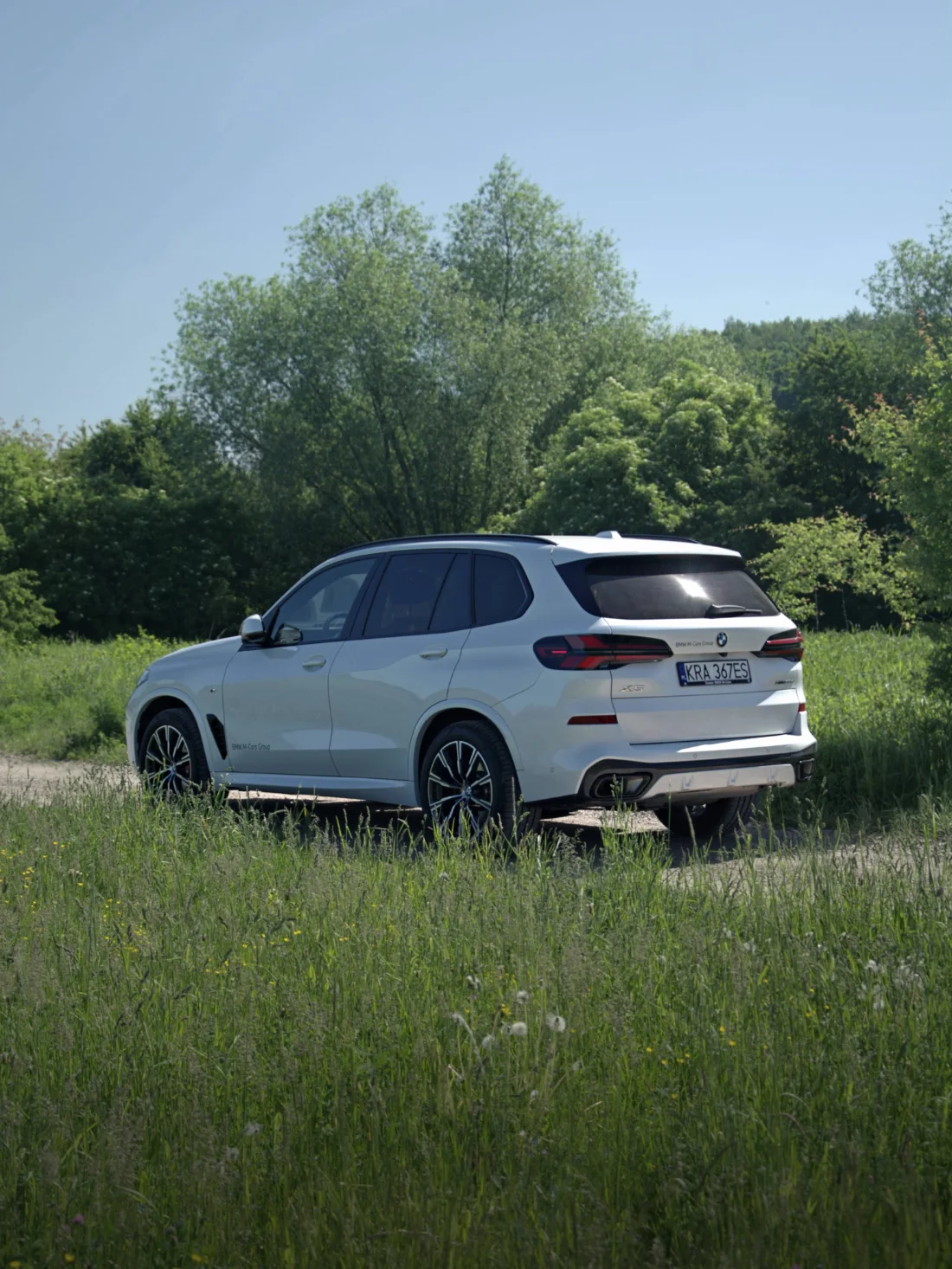 BMW X5 xDrive30d 2025 z boku i tyłu w plenerze, SUV premium BMW M-Cars