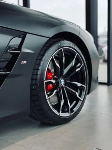 BMW Z4 M40i, zbliżenie na sportową felgę i czerwony hamulec M w salonie BMW M-Cars